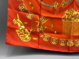 a red and gold scarf with a crown on it