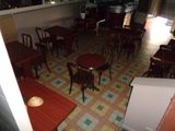 Il y a beaucoup de tables et de chaises dans ce petit restaurant.