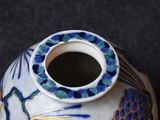 a blue and white vase with a bird design on it