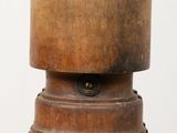 an old wooden bell sitting on top of a table next to a white wall
