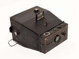 an old camera that is sitting on a white surface