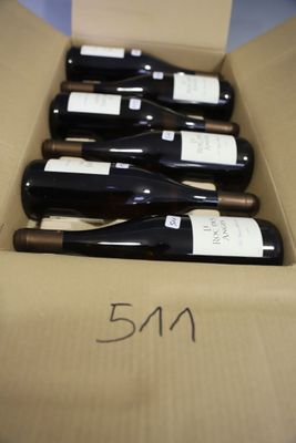 several bottles of wine are in a cardboard box on a table