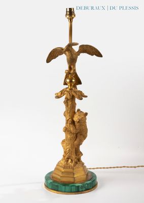 a gold lamp that has a bird on top of it