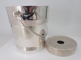 a silver bucket and a roll of toilet paper on a white surface
