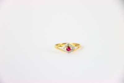 une bague en or jaune sertie d'un rubis et d'une topaze blanche
