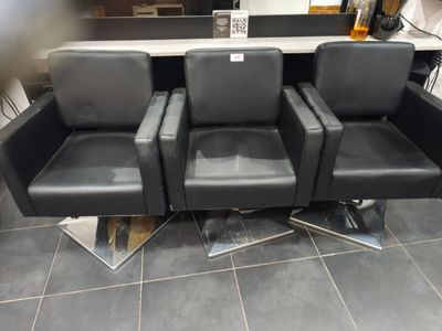 trois chaises noires posées sur un sol carrelé