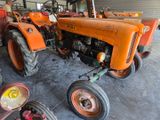 a tractor that is sitting in a garage with other tractors