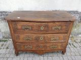 une commode en bois posée sur un sol en briques