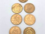 a group of five gold coins sitting on top of a white surface
