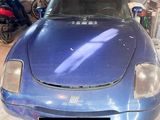une photo d'une voiture de sport bleue dans un garage