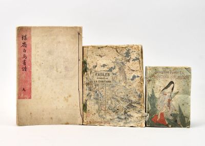 trois livres superposés sur une surface blanche