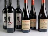 plusieurs bouteilles de vin rouge sont alignées sur une table