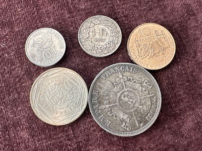 quatre pièces de monnaie britanniques différentes posées sur un tissu violet