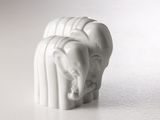 une figurine d'éléphant blanc posée sur une surface blanche