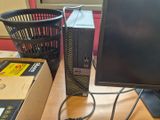 un ordinateur de bureau posé sur un bureau, à côté d'un panier