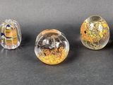 six different colored glass eggs sitting on top of a black surface