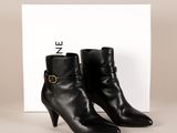 une paire de bottines en cuir noir ornées d'une boucle dorée