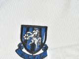a close up of a soccer shirt with a crest on it