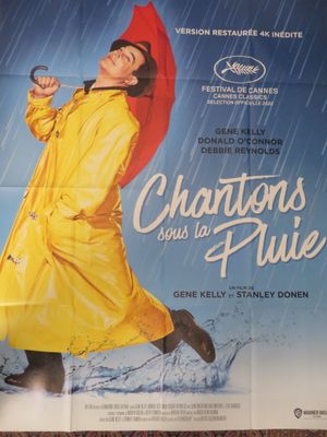 affiche de cinéma représentant une femme en imperméable jaune tenant un parapluie rouge