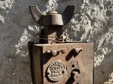 an old rusted machine sitting on the side of a building