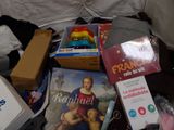 a pile of books and toys on a bed