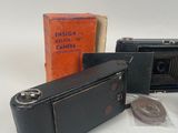 two old cameras and a coin on a table