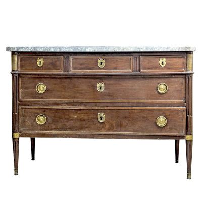 an antique chest of drawers with marble top and brass handles