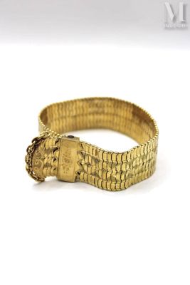 a close up of a gold bracelet on a white surface