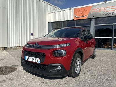 une citrole rouge garée devant un immeuble