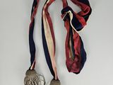 a red, white, and blue ribbon with tassels hanging from it