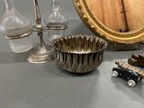 a silver vase and a mirror on a table
