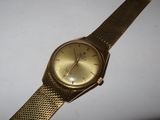 an image of a gold watch sitting on a white surface