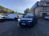 La voiture bleue est garée devant l'immeuble, sur le parking.