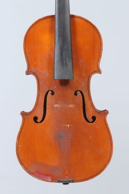 an old violin sitting on top of a white surface