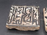 these are two pieces of pottery with designs on them on a black surface