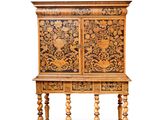 une vieille commode en bois dont les portes et les tiroirs sont sculptés