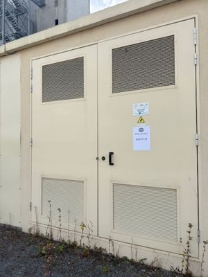 a white building with two doors and a sign on it