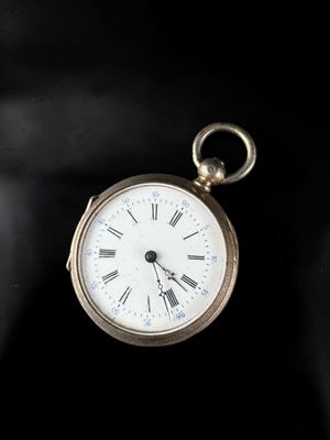 a gold pocket watch with roman numerals on the face