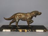 statue of a dog on a marble base on a gray background