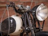 a black and white motorcycle parked in front of a brick wall