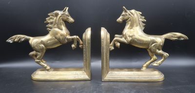 pair of brass horse bookends on a black background