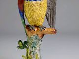 une figurine représentant un oiseau perché sur une branche d'arbre