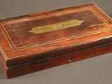 une vieille boîte en bois sur laquelle est fixée une plaque en laiton