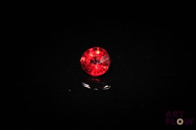 a close up of a red ball on a black surface