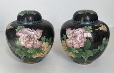 deux vases décorés de fleurs, posés sur une table