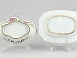 two porcelain plates with gold trims and flowers on them