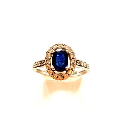 gros plan d'une bague avec une pierre bleue entourée de diamants