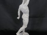 a white marble statue of a man holding a tennis racket