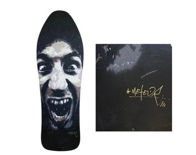 Le skateboard est décoré d'une illustration représentant le visage d'un homme.