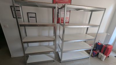 deux étagères sur lesquelles sont posés des bagages dans la pièce
